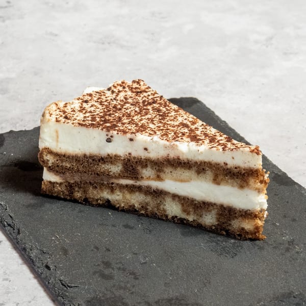 A slice of tiramisu with layers of coffee-soaked cake and cream, dusted with cocoa powder.
